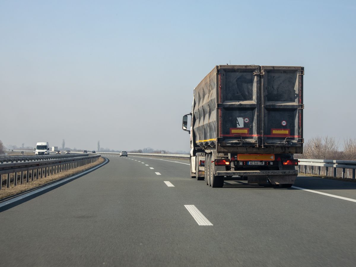 Caminhão de carga seguindo por uma rodovia
